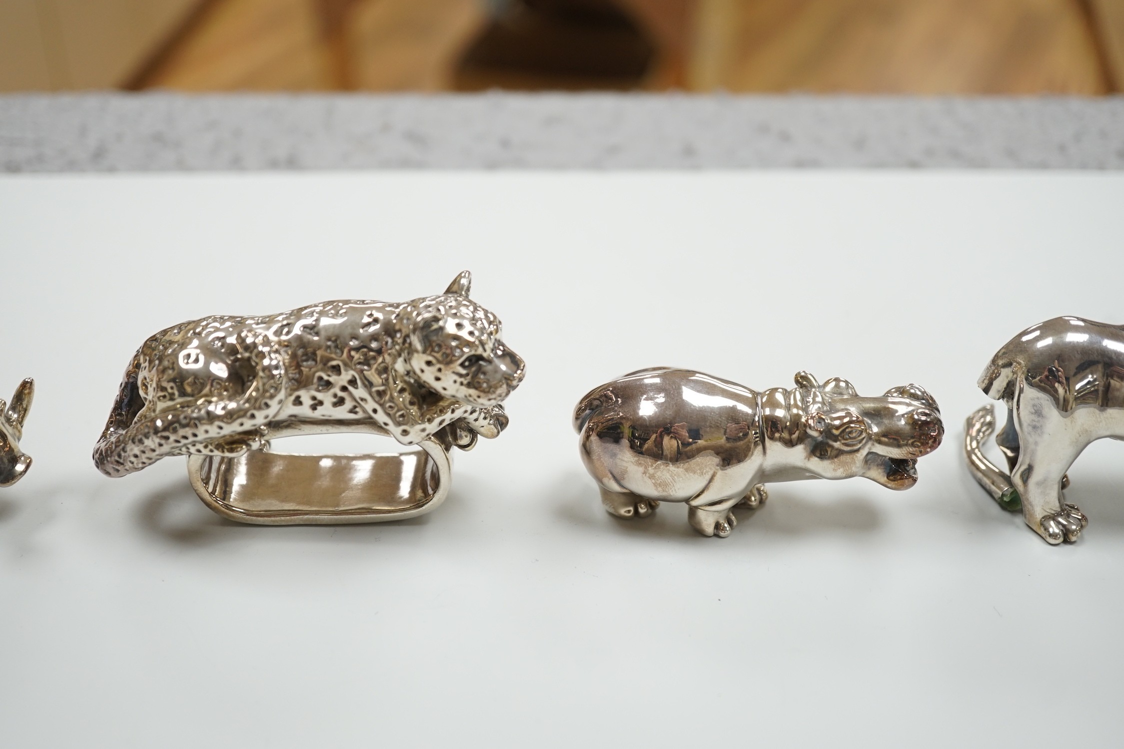 Four modern 925 overlaid miniature models of animals including two lions and a similar leopard napkin ring (one lion a.f.).